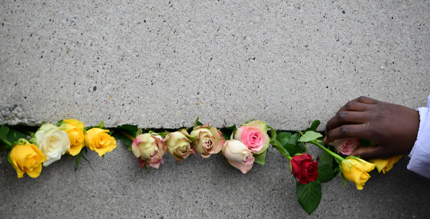 Un visitante coloca una flor en el monumento conmemorativo del Muro de Berlín durante el servicio conmemorativo del sábado © Tobias Schwarz / AFP